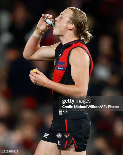 Mason Redman of the Bombers drinks some pickle juice during the 2023 AFL Round 17 match between the Essendon Bombers and the Adelaide Crows at Marvel...