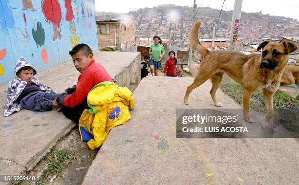 Un niño acomoda el calzado de su hermanito en Cazuca, uno de los barrios de Ciudad Bolívar, Bogotá, el 26 de octubre de 2005. En Ciudad Bolívar, una...