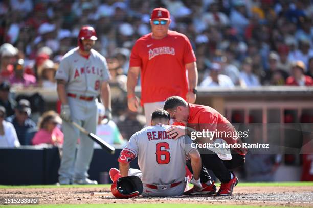 Anthony Rendon of the Los Angeles Angels lays on the field while being checked by a trainer after an injury sustained during the fourth inning...