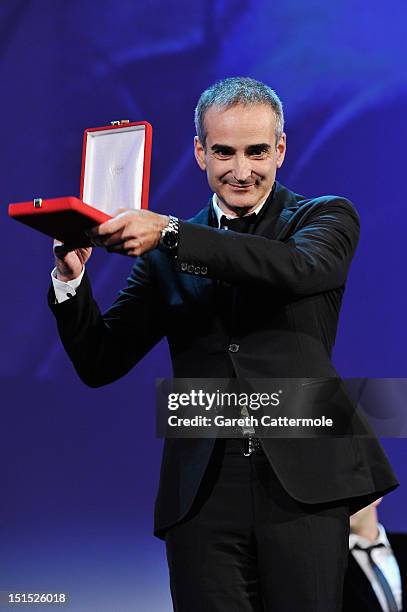 Director Olivier Assayas with his award for Best Screenplay for the film "Apres Mai" on stage during the Award Ceremony at the 69th Venice Film...
