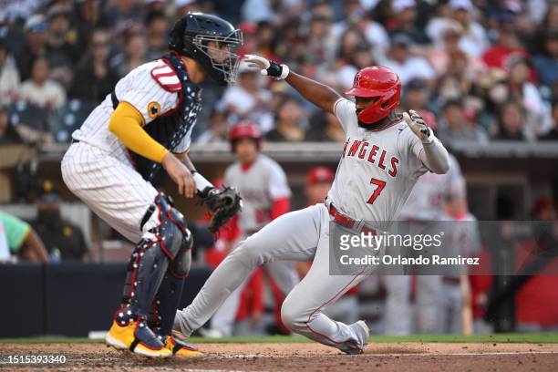 Jo Adell of the Los Angeles Angels slides into score ahead of Gary Sanchez of the San Diego Padres during the ninth inning at PETCO Park on July 04,...