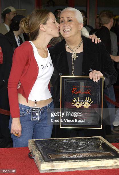 Musician Grace Slick gets a kiss from daughter actress China Kantner at a handprint ceremony inducting Slick into the Hollywood Rock Walk at the...