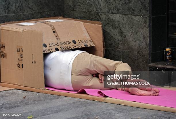Homeless person sleeps in a street of the centre of Madrid on July 9, 2023.
