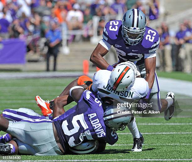 Defenders Jarard Milo and Adam Davis of the Kansas State Wildcats tackle running back Duke Johnson of the Miami Hurricanes during the second quarter...