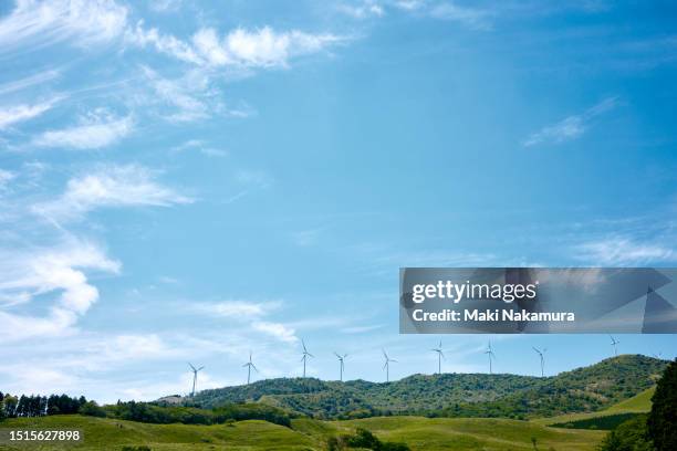 wind turbines spinning across the blue sky and green meadows. - horizont über land stock-fotos und bilder