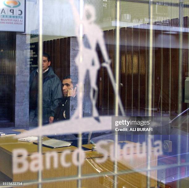 Two security guards stand guard inside el Banco Suquia in the finacial zone of Buenos Aires 19 May 2002 after the french bank, Credit Agricole,...