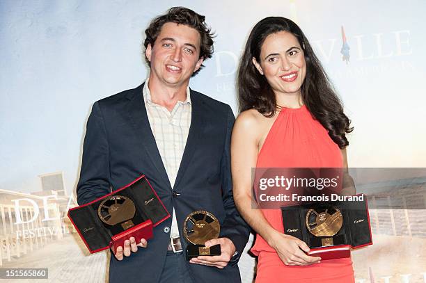 Directors Lucy Mulloy and Benh Zeitlin pose with their trophies after at the closing ceremony of the 38th Deauville American Film Festival on...