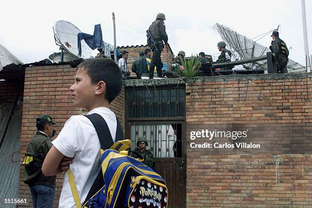 Child watches police special forces conducting raids in the Pablo Neruda neighborhood after a bomb went off near police headquarters October 22, 2002...