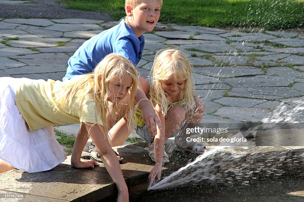 Children playing with fountain