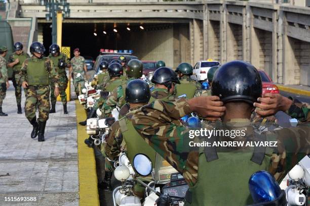 Venezuelan National Guard soldiers stand guard in an empty Caracas street as a national strike went into effect 10 December, closing down businesses...