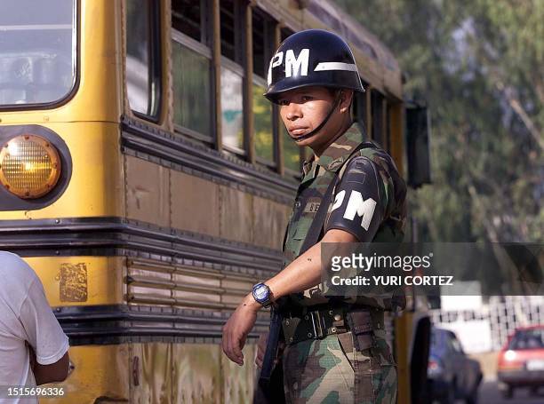 Military police officer is seen guarding a government mandated bus 29 November 2001 in El Salvador, San Salvador. Un policia militar custodia un...