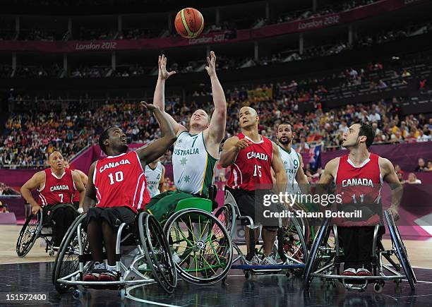 Shaun Norris of Australia is challenged by Abdi Dini and David Eng of Canada during the gold medal Wheelchair Basketball match between Australia and...