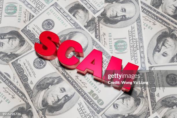 scam text with us dollars background,3d render - broma pesada fotografías e imágenes de stock