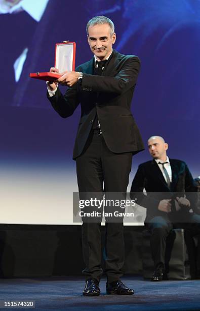 Director Olivier Assayas with his award for Best Screenplay for the film "Apres Mai" on stage during the Award Ceremony at the 69th Venice Film...