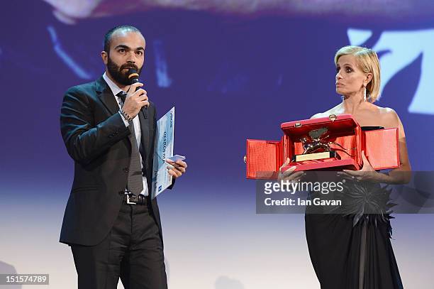Director Ali Aydin accepts his 'Luigi De Laurentiis' Award for Debut Film 'Kuf' from jury member Isabella Ferrari during the Award Ceremony at the...