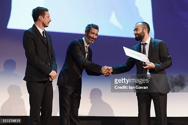 Luca Bizzarri and Paolo Kessisoglu with director Ali Aydin poses with his award for the Lion of the Future 'Luigi De Laurentiis' Venice Award for...