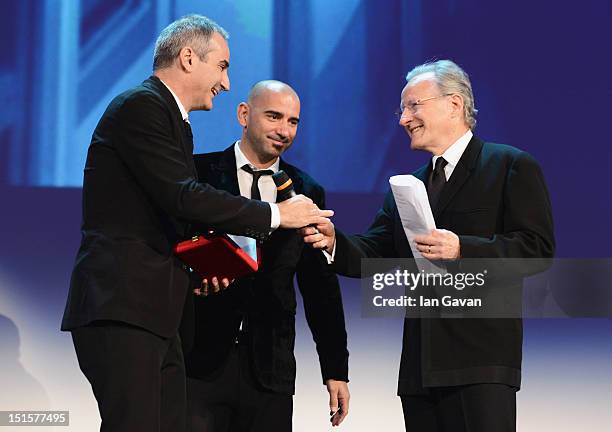 Director Olivier Assayas receives the award for Best Screenplay for the film "Apres Mai" from Jury President Michael Mann on stage during the Award...