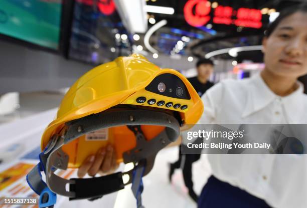 Staff member shows intelligent helmet at China Unicom booth during an exhibition of the Global Digital Economy Conference 2023 at the China National...