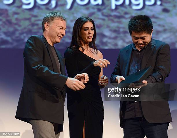 Director Wang Bing as he wins the Orizzonti Award for Best Film on stage with jury members Milcho Manchevski and Nadine Labaki during the Award...