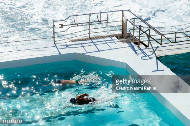 two swimmers do a lap of the bondi icebergs swimming club pool - sport bahnrunde stock-fotos und bilder
