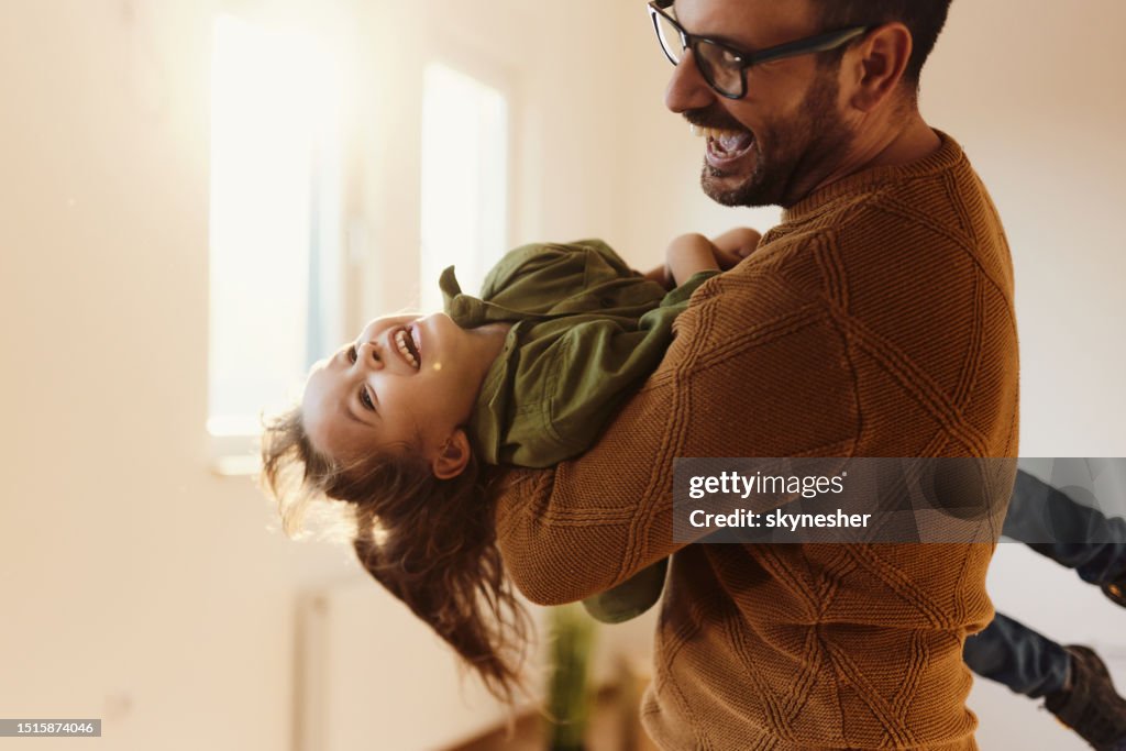 Playful father having fun with his daughter in a new home.