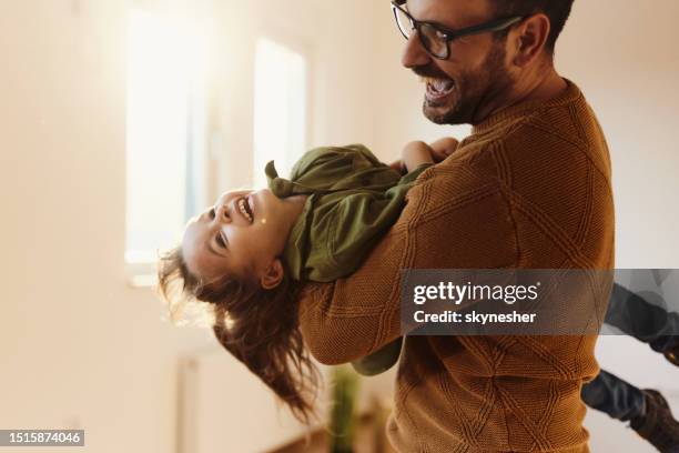 playful father having fun with his daughter in a new home. - life events stock pictures, royalty-free photos & images