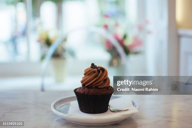 cute chocolate cupcake in a pretty cafe - fancy cupcake stock pictures, royalty-free photos & images