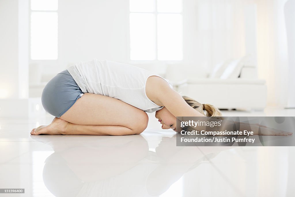 Young woman practicing yoga in living room