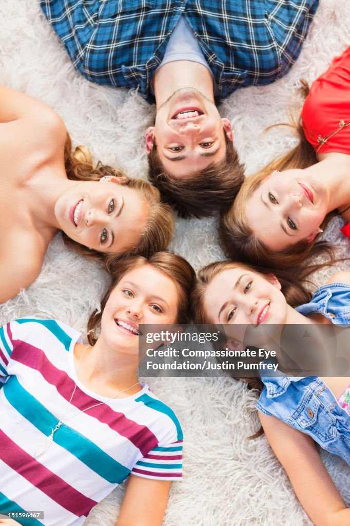 Group of friends lying on rug, overhead view