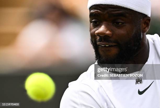 Player Frances Tiafoe eyes the ball as he returns it to Bulgaria's Grigor Dimitrov during their men's singles tennis match on the seventh day of the...