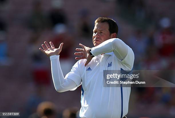 Head coach Jim Mora of the UCLA Bruins signals during warmups before the game against the Nebraska Cornhuskers at the Rose Bowl on September 8, 2012...