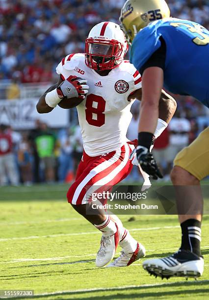 Running back Ameer Abdullah of the Nebraska Cornhuskers carries on a six yard touchdown run in the first quarter against linebacker Jordan Zumwalt of...