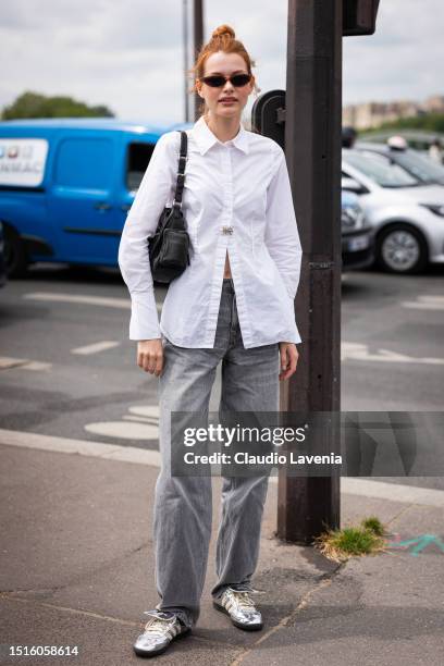 Model wears a white shirt, grey jeans, sunglasses and a black leather bag, outside Chanel, during the Haute Couture Fall/Winter 2023/2024 as part of...