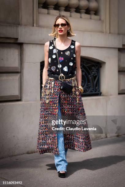 Helena Bordon wears a black decorated Chanel tank top, a Chanel tweed maxi skirt over Chanel jeans, black belt, black Chanel mini bag, black platform...