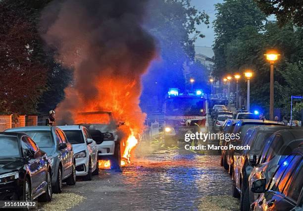 Flames engulf a pickup truck as fire department responders approach on July 05, 2023 in Halle, Germany. Police so far have not said whether the blaze...