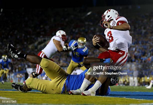 Quarterback Taylor Martinez of the Nebraska Cornhuskers is tackled for a safety by defensive end Datone Jones of the UCLA Bruins in the fourth...