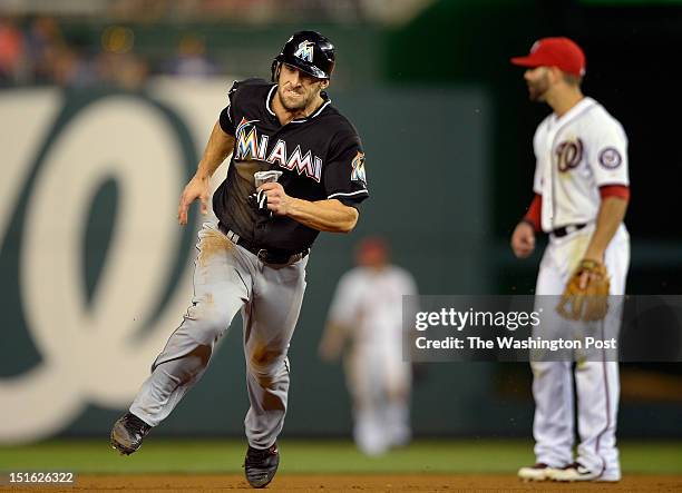 Marlins' Bryan Petersen , left, heads from first to third base past Nationals' second baseman Danny Espinosa , right, on a Justin Ruggiano top of the...