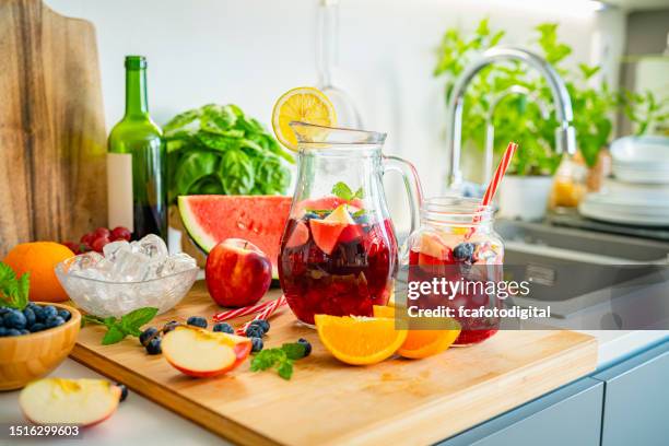 freshly prepared sangria and ingredients on kitchen counter - sangria stock pictures, royalty-free photos & images