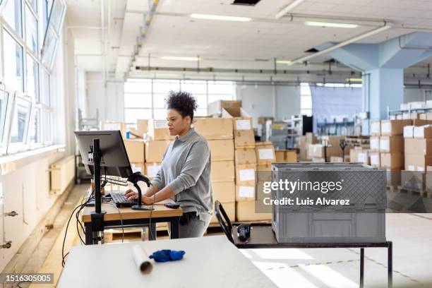women worker working on computer terminal at fulfilment centre - ergonomie stockfoto's en -beelden
