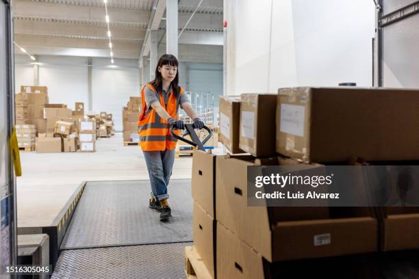 asian woman worker loading a delivery truck in distribution warehouse - inside truck stock pictures, royalty-free photos & images
