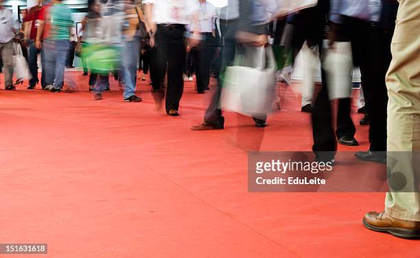 pedestrians walking on a red carpet - tradeshow 個照片及圖片檔