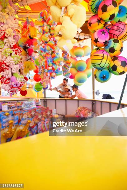 family at a seaside funfair - winnings stock pictures, royalty-free photos & images