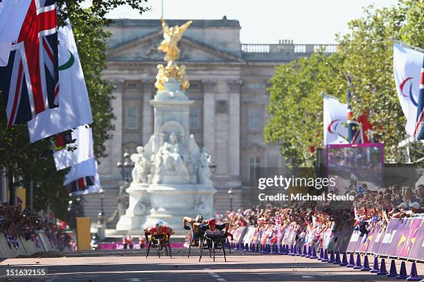 David Weir of Great Britain heads towards victory and his fourth gold medal of the Paralympic Games from Marcel Hug of Switzerland and Kurt Fearnley...