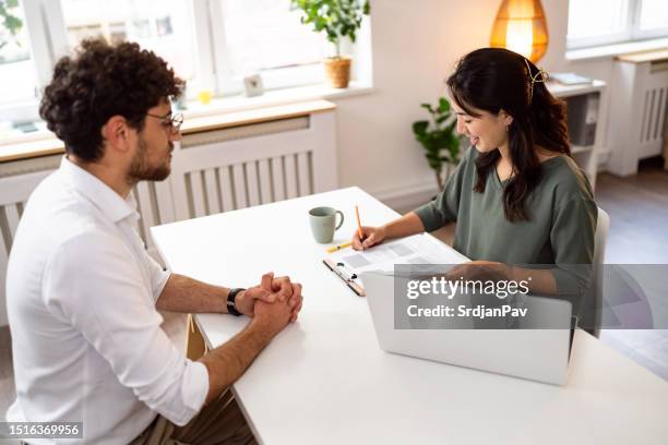 male candidate having an interview with a female recruiter japanese ethnicity at the office - cv bildbanksfoton och bilder
