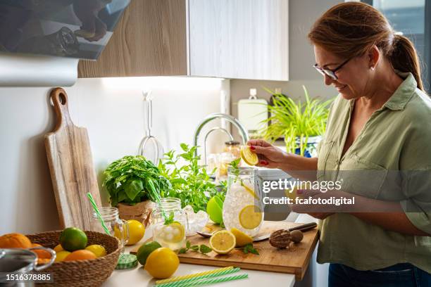 woman preparing fresh lemonade - jug stock pictures, royalty-free photos & images