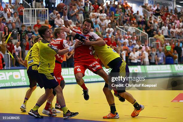 Torsten Laen of Berlin and Ivan Nincevic of Berlin challenge Philipp Poeter of Essen during the DKB Handball Bundesliga match between TUSEM Essen and...