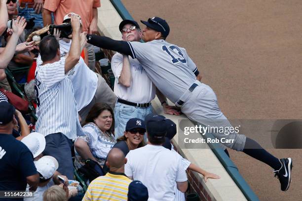 Fan catches a foul ball hit by Mark Reynolds of the Baltimore Orioles in front of third baseman Alex Rodriguez of the New York Yankees during the...