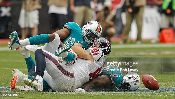 Owen Daniels of the Houston Texans loses the ball after taking a hard hit by the Miami Dolphins defense during their season opener at Reliant Stadium...