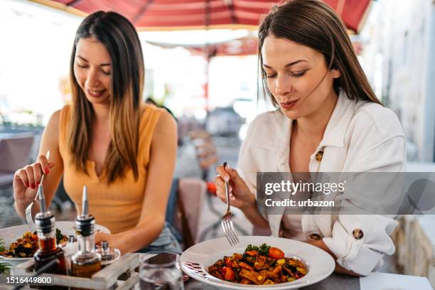 two female friends eating at the restaurant in dubrovnik - croatia food stock pictures, royalty-free photos & images