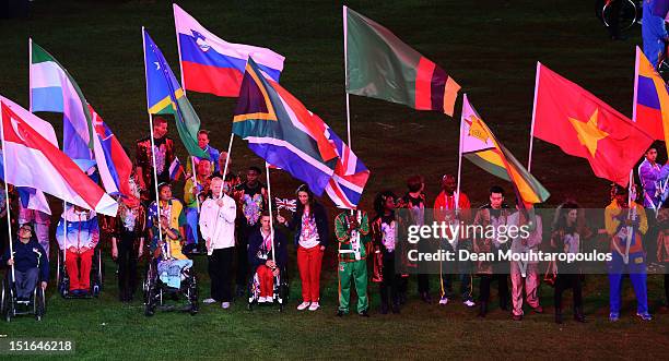 Athlete David Weir and cyclist Sarah Storey of Great Britain carry the flag join fellow flagbearers during the closing ceremony on day 11 of the...